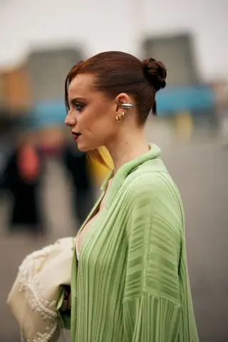 woman with a tight bun and green shirt