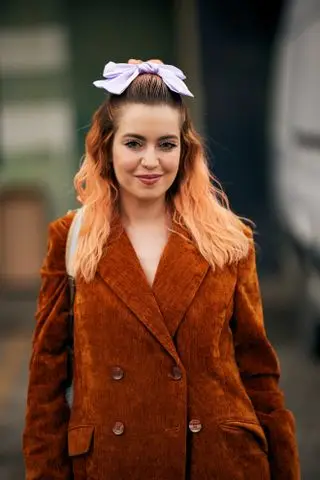 woman with a bow in her hair and an orange jacket