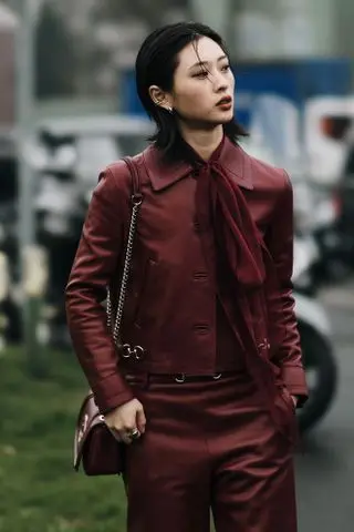 woman in a burgundy suit with dark hair and dark lipstick