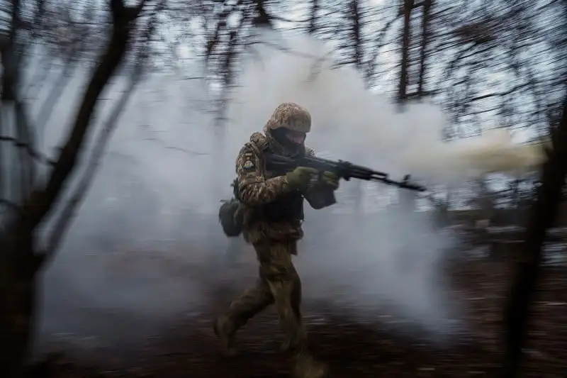 A Ukrainian serviceman trains in the woods near the frontline in Ukraine.