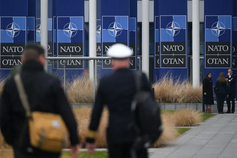 People stand in front of NATO headquarters in Brussels.