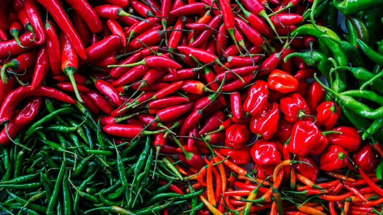 Assorted red and green spicy peppers filling frame