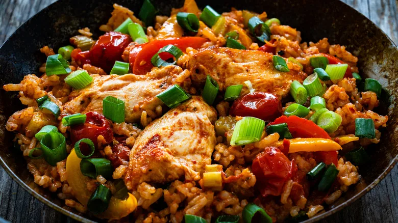Close-up of colorful jamblaya with chicken and green onions on top