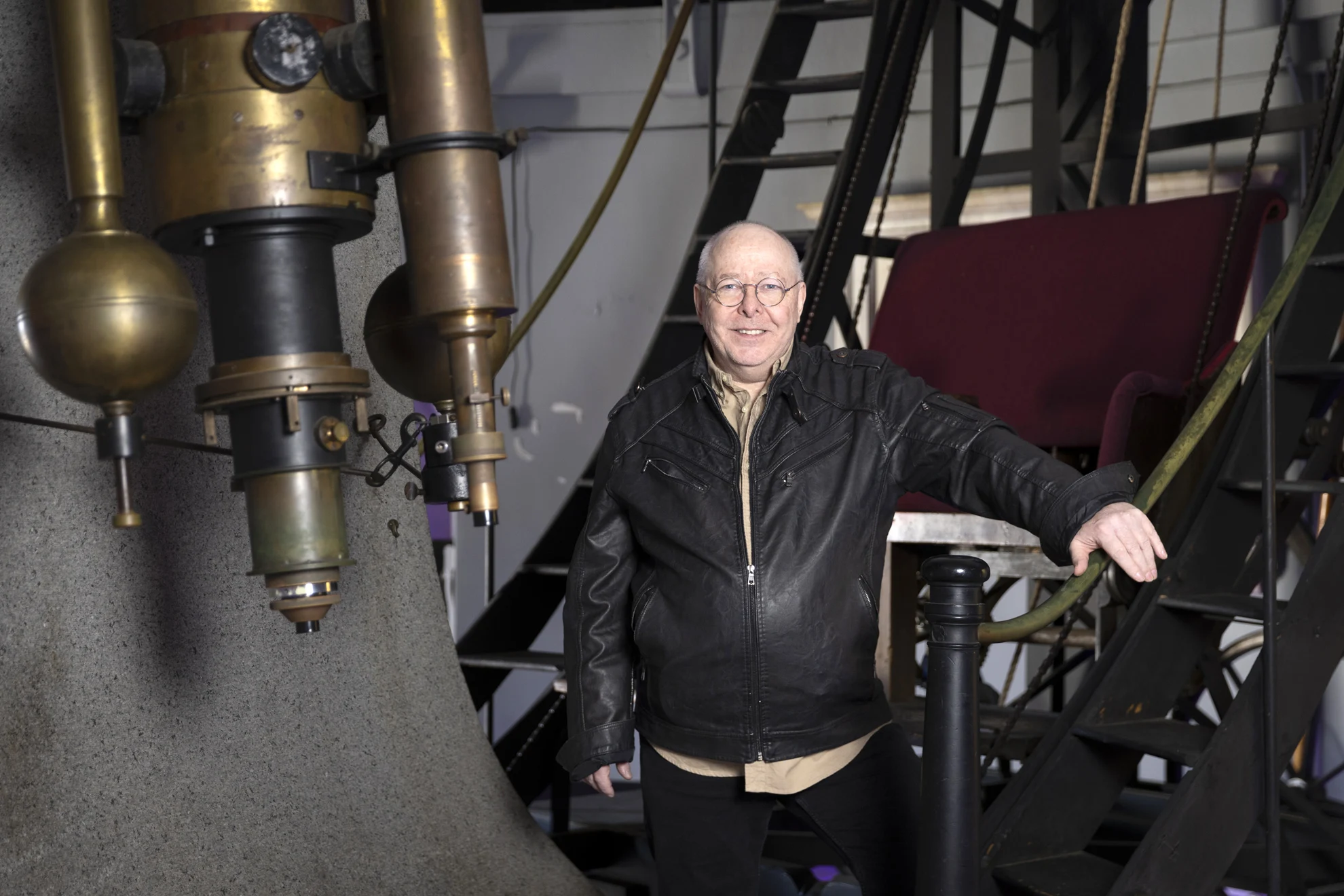 John Buonomo, Senior Cloud Architect and astrophotographer, posing for photos with the Great Refractor at the Harvard Center for Astrophysics.
