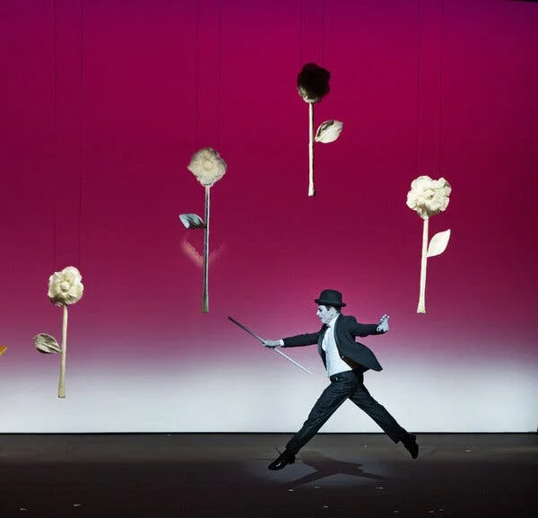 A man in a suit walking amid flowers seemingly suspended in mid air.