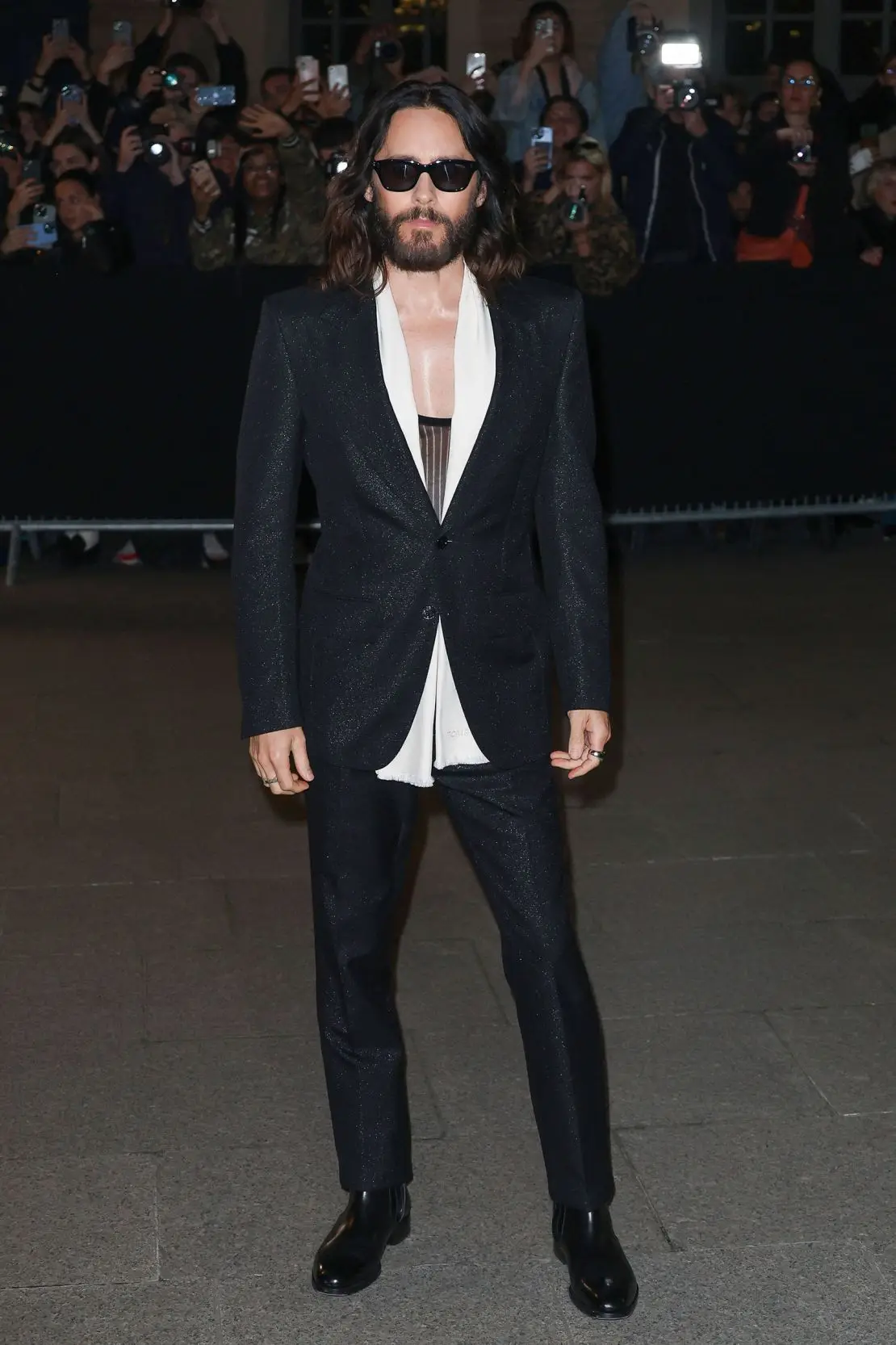 Actor Jared Leto outside the Tom Ford show in a shimmering blazer worn over a low cut top.