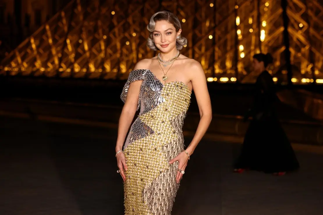 Wearing a gold dress by Jeremy Scott, model Gigi Hadid exuded glamour at the Louvre.