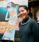 Van Le stands in front of a painting of her mother done by her late father, Le Quang Vinh on March 27, 2025. Le and her uncle Allen Luong are coordinating a series of exhibits that will showcase her father's paintings. The first event will be on April 5, 2025.