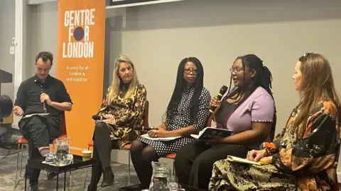 Noah Vickers/Local Democracy Reporting Service A panel of one man and four women sat on chairs in a room, one of the women is speaking into a mic. There are posters behind them saying 'Centre for London' and 'Welcome'.