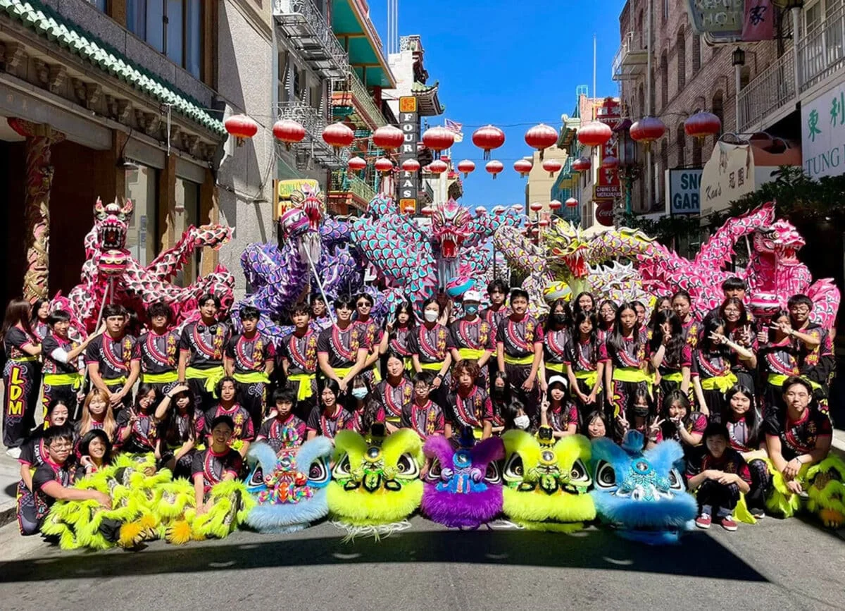 Alameda Post - a large team of dragon dancers pose on the street
