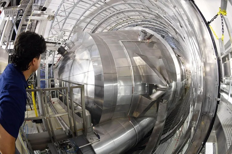 A Karlsruhe Tritium Neutrino Experiment researcher looks into the main spectrometer of the device at the Karlsruhe Institute for Technology.
