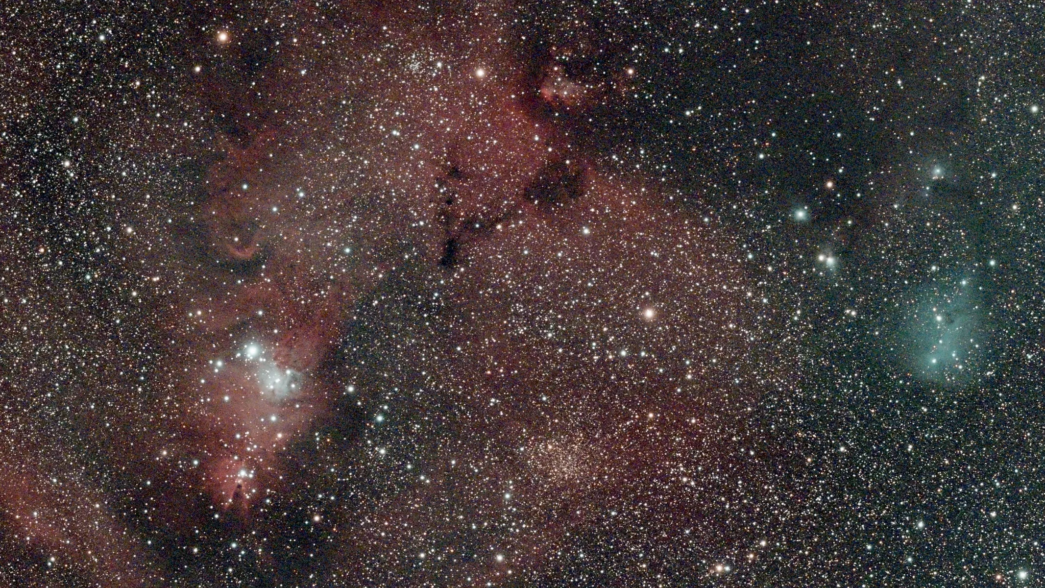 A view of a nebula, with stars and red clouds.