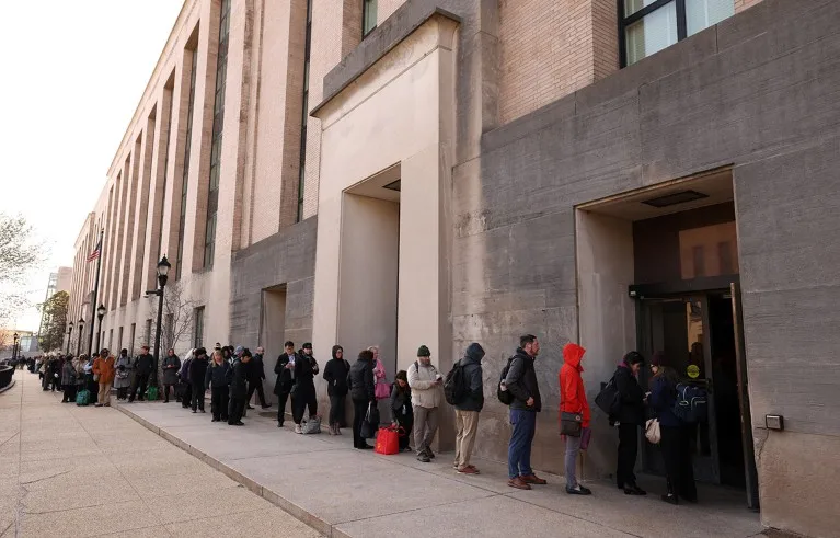A long line of employees of the Department of Health and Human Services queue to access the Mary E. Switzer Memorial Building.