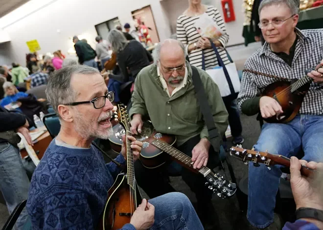 A trio of musicians holding string instruments perform folk music at Spokane Community College during the annual Fall Folk Festival.