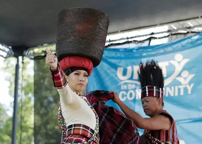 A woman in traditional dress performs a cultural dance on stage at Unity in the Community.