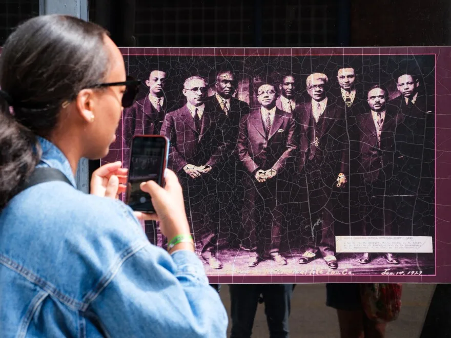 An attendee takes a picture of the North Carolina Mutual Life Insurance founders, the largest Black-owned insurance company, during a walking tour of Durham's Black Wall Street.