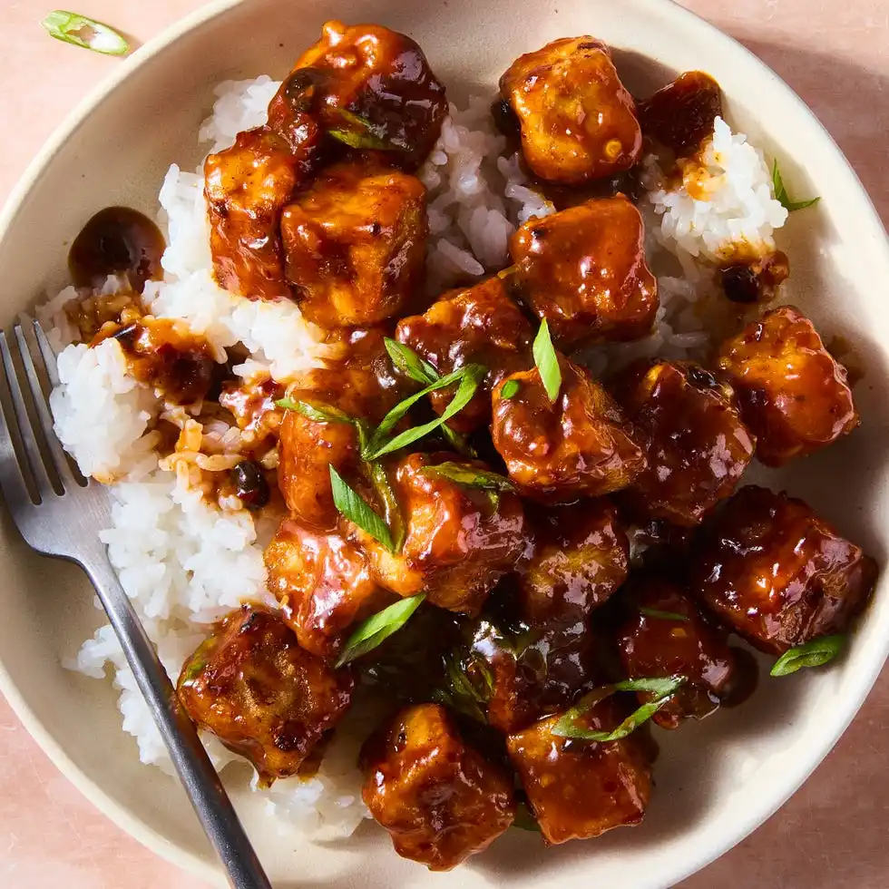 Chili crisp frid tofu chili crisp fried tofu over rice in a bowl topped with scallions