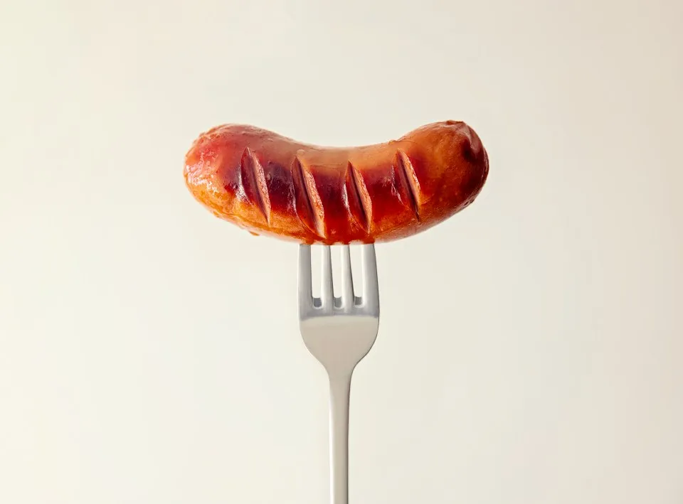 Grilled sausage on a fork.
