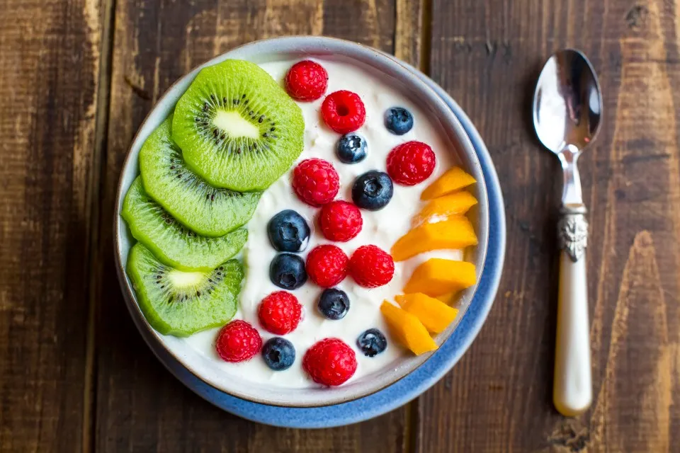 Yogurt bowl with kiwi, raspberries, blueberries, and mango.