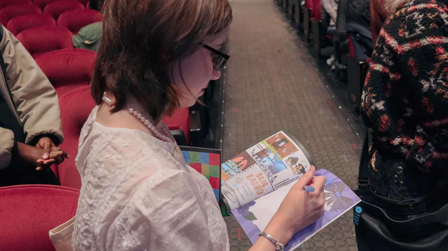 Photo of Megan Prunty (BFA 2024 Animation) signing a friend’s Thesis Zine at the Animation Celebration Screening.