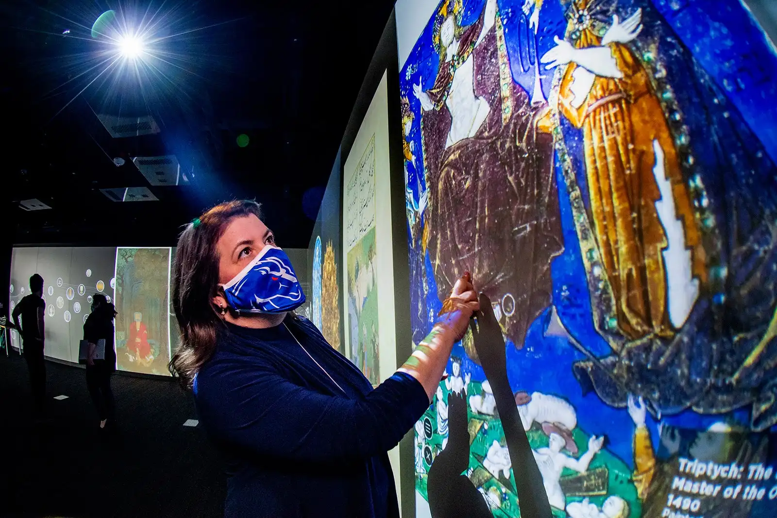 Woman looks at art on digital touchscreen