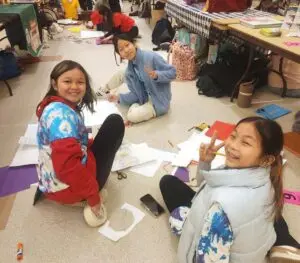 kids sitting on floor doing artwork