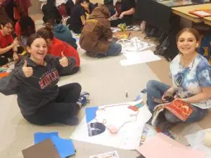 kids sitting on floor doing art work