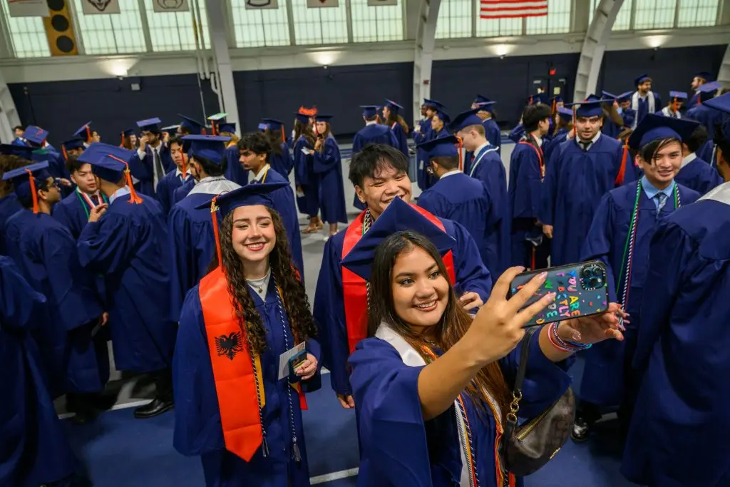 A group of graduates taking a selfie in their caps and gowns