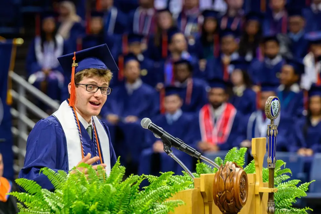 Student graduate speaking into a mic