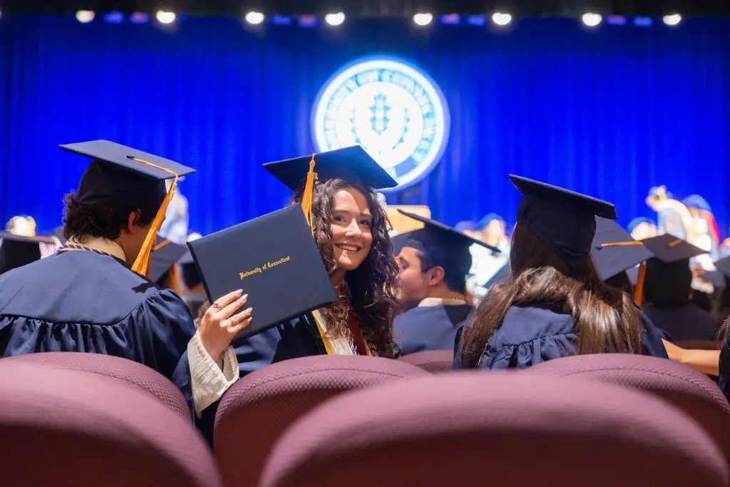 A student holding up her diploma