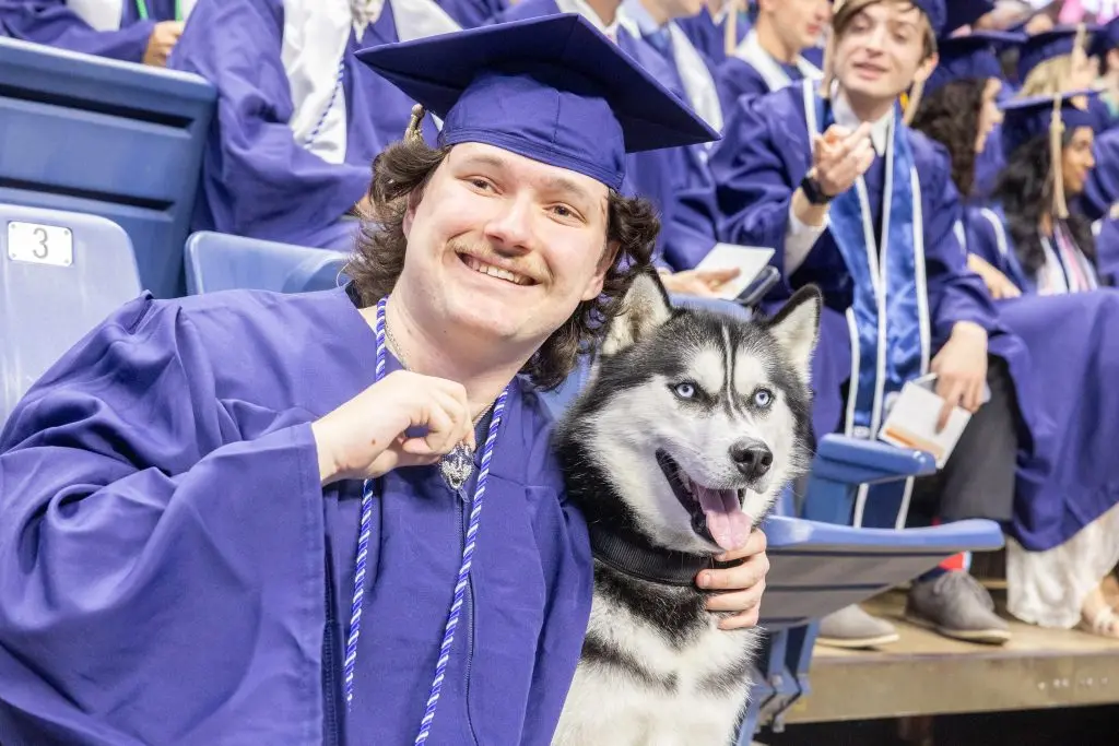 Jonathan with student holding a husky necklace
