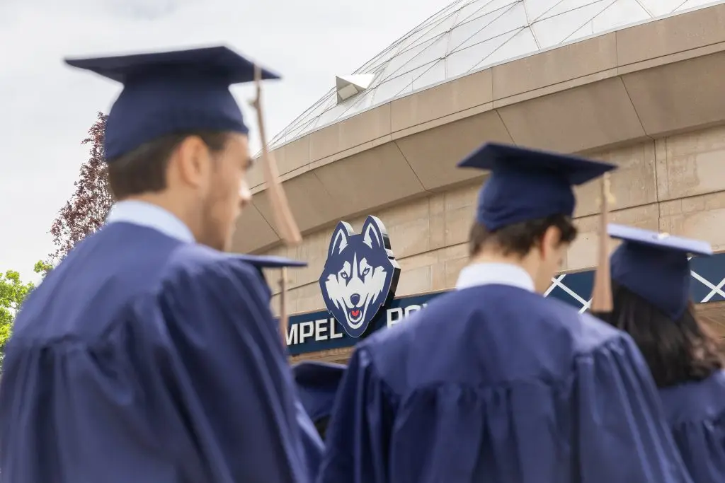 Graduates of the School of Business walk into Gampel Pavilion