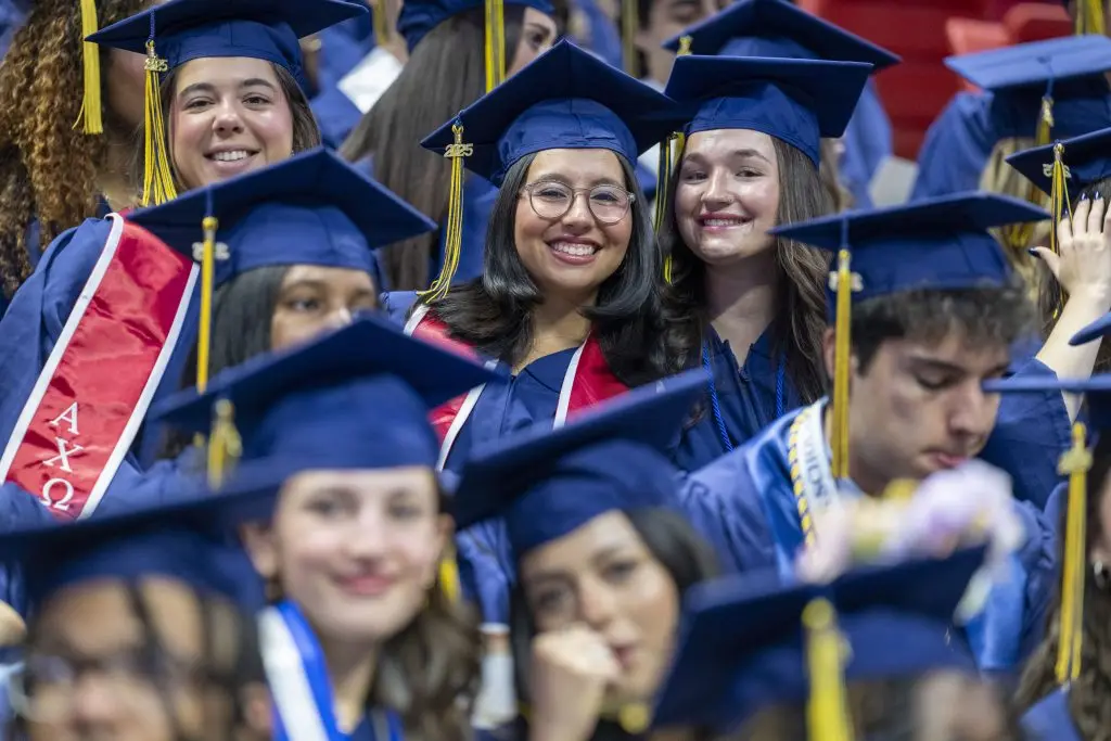 Students in their cap and gown posing for a photo
