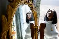 Voke Onoriose poses for a portrait with an antique mirror her late father gave to her in her...