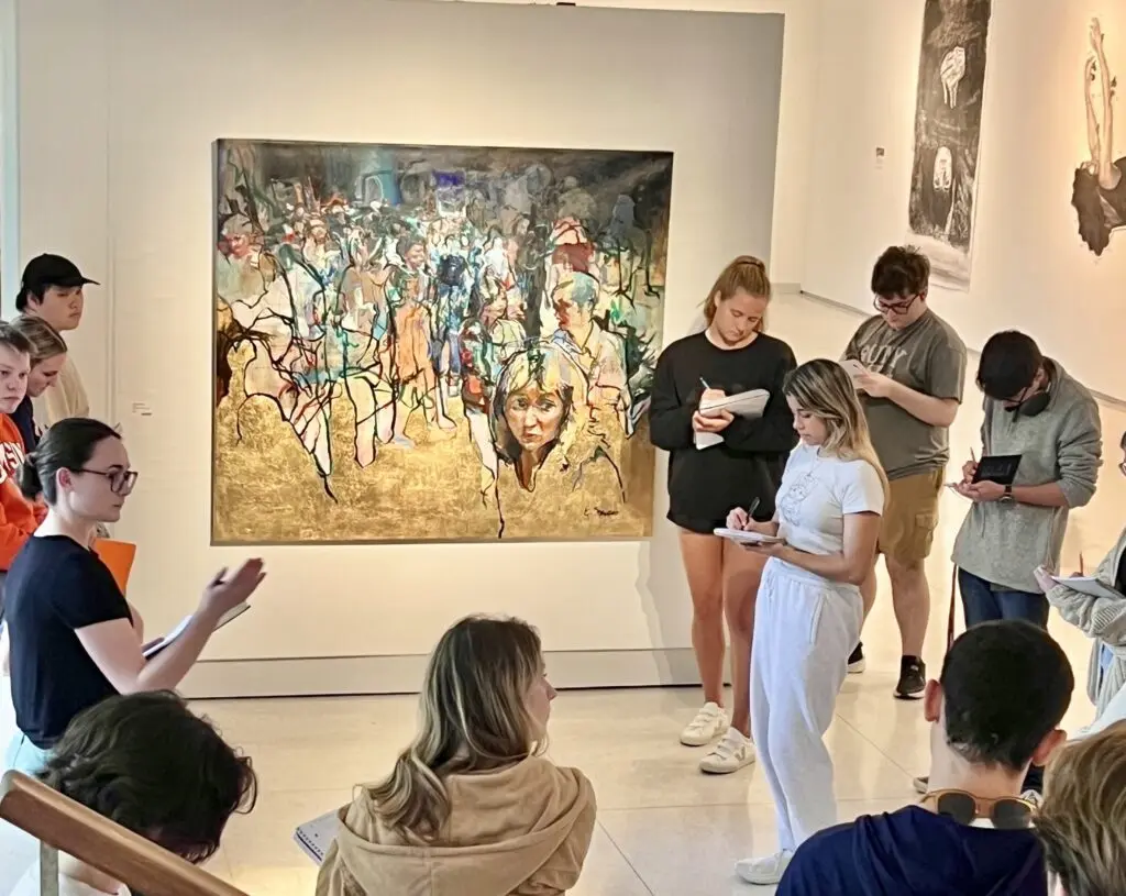 Art student Maya McDonald '25, co-curator of the Conversations exhibition, leads high school students in a discussion in the Lee Gallery.