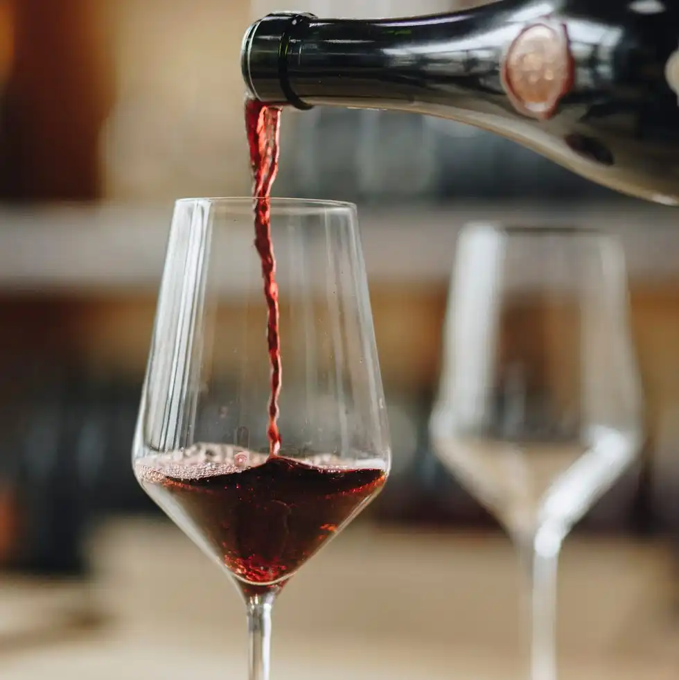 red wine poured from bottle into wineglass