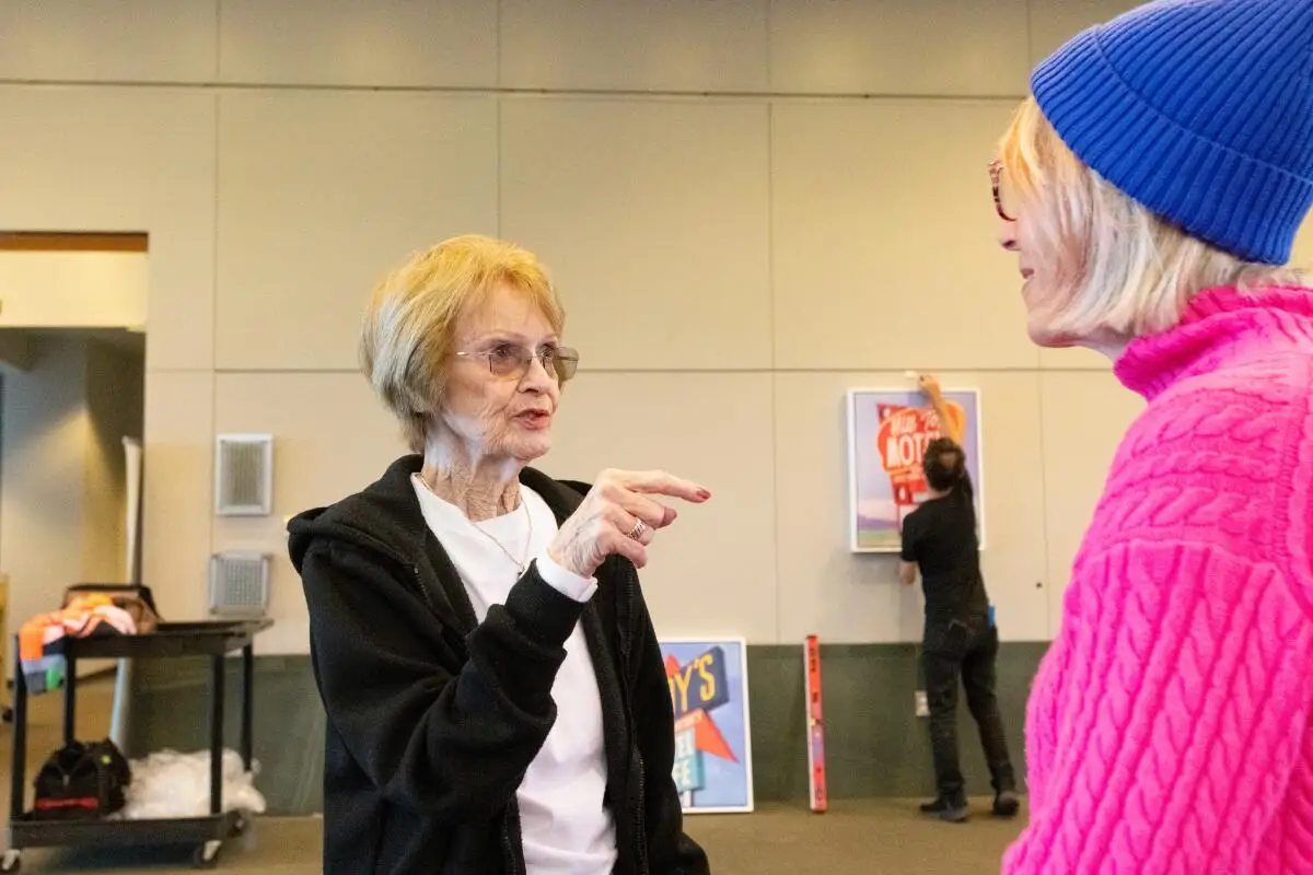 A library visitor chats with Laguna Beach-based artist Joan Gladstone Monday, May 5.