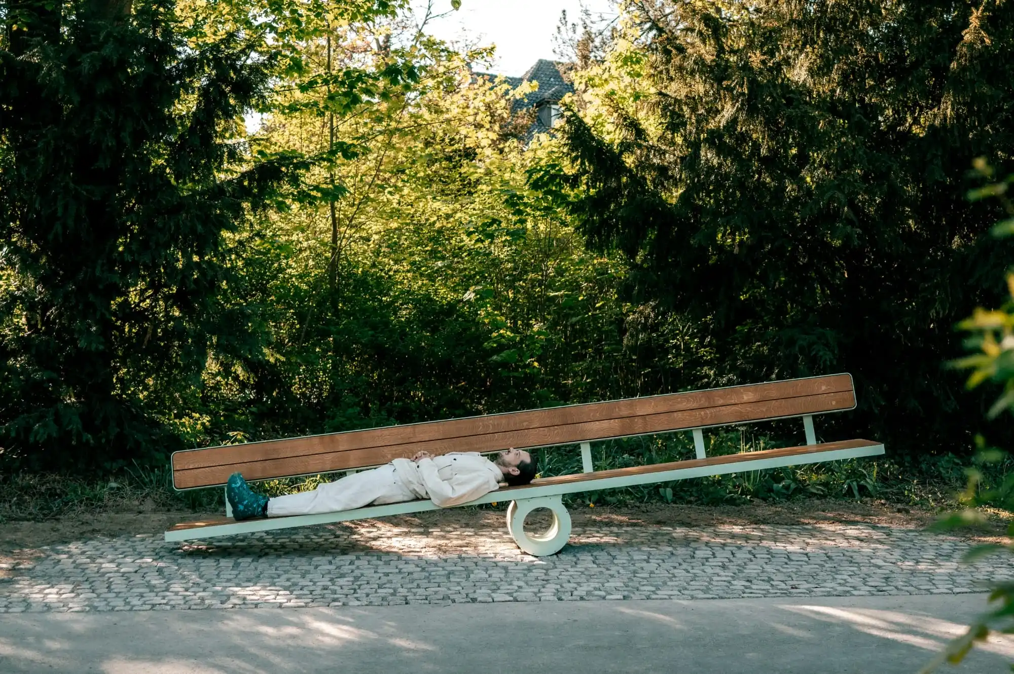 a white man lays on a bench that tilts toward his weight