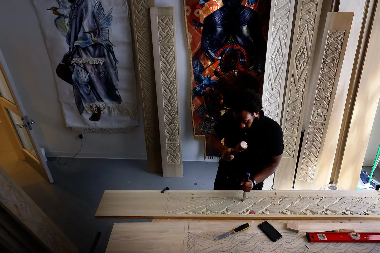 Stephen Hamilton carves wood for the looms in his Triennial installation.