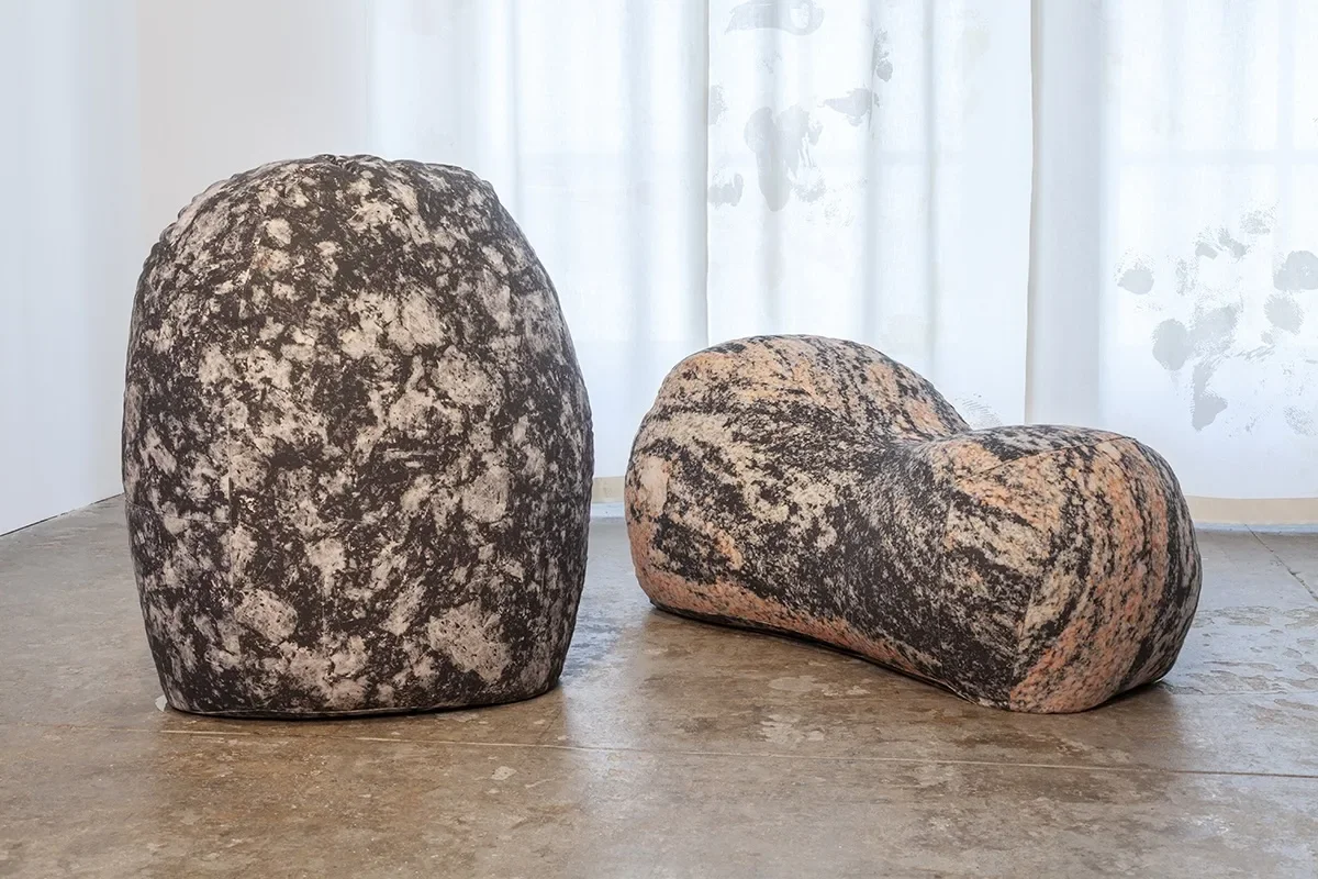 Movement towards Freedom - Brendan Fernandes at the Fabric Workshop and Museum 2 Two large, rock-like soft sculptures in mottled markings of pink, grey, black and white, sit on a concrete floor in a museum.The works, by Brendan Fernandes, are references to Scott Burton.