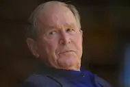 Former U.S. President George W. Bush watches the third inning of a baseball game between the...