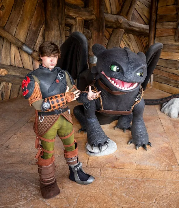 An actor playing Hiccup facilitates guest interactions with Toothless the dragon within How to Train Your Dragon - Isle of Berk at Universal Epic Universe. (Patrick Connolly/Orlando Sentinel)