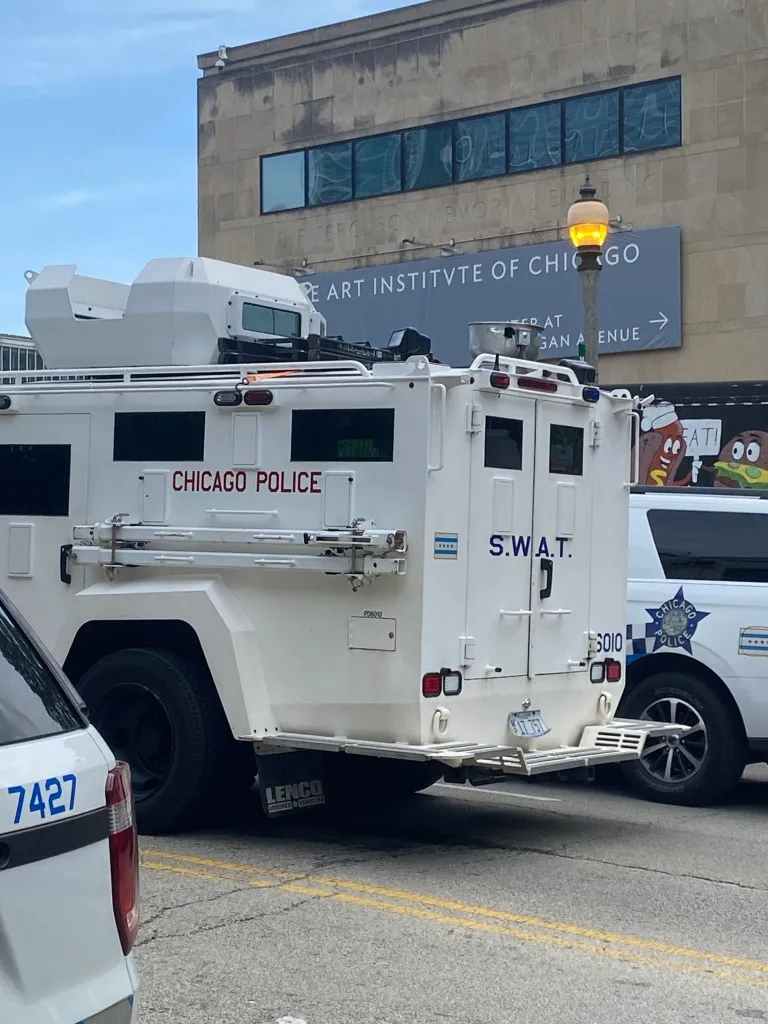 Chicago Police Department vehicles and a large SWAT team truck are parked in front of the Art Institute of Chicago.