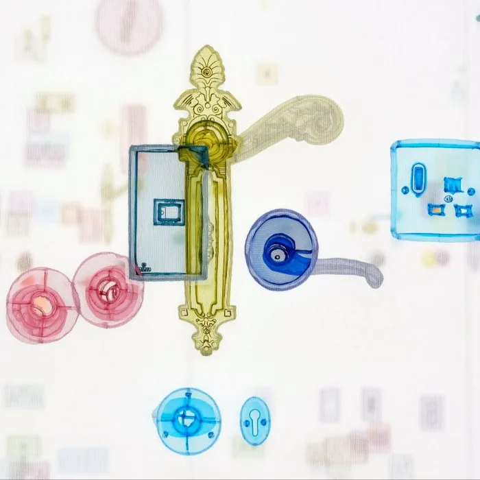 A sculpture featuring colourful transparent door handles and light switches in yellow, blue and pink 