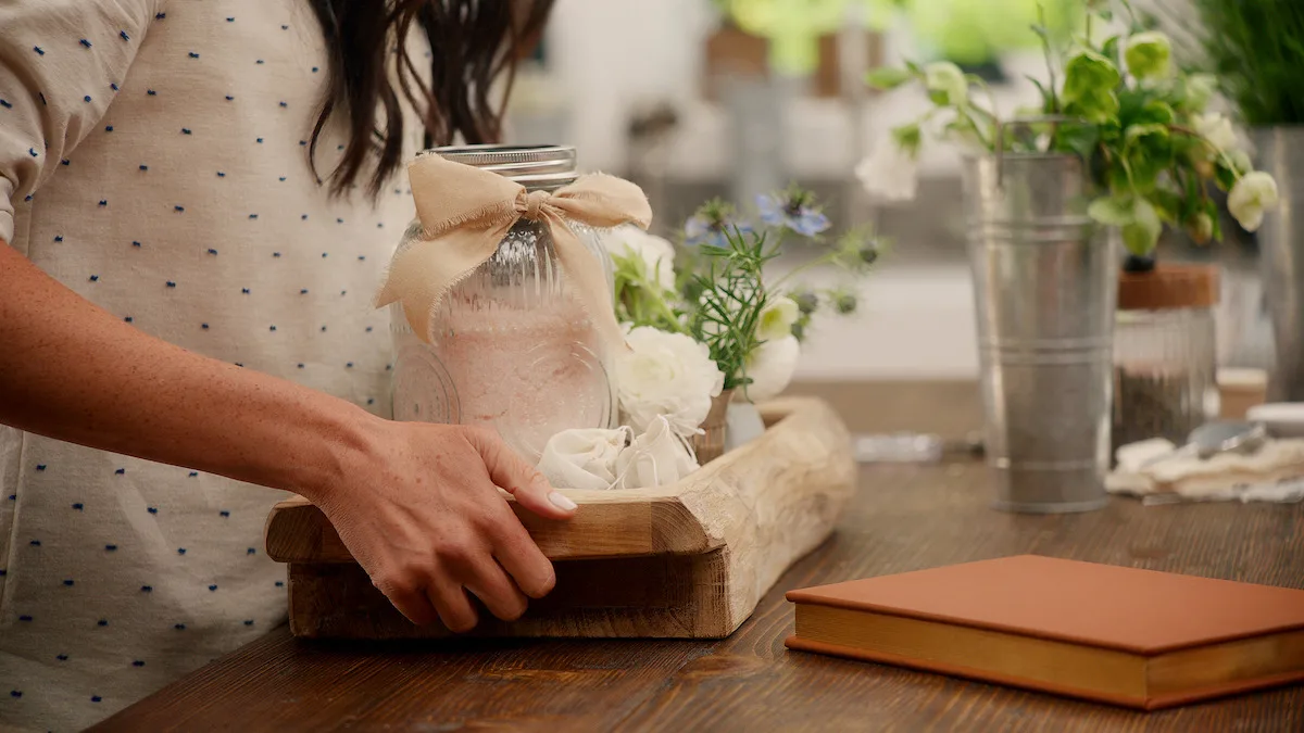Meghan holds a tray with salt and flowers on it.