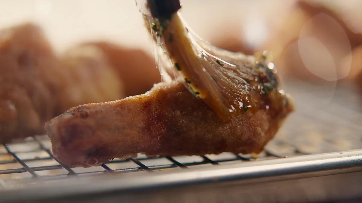 Korean crying tiger sauce being spread onto fried chicken.