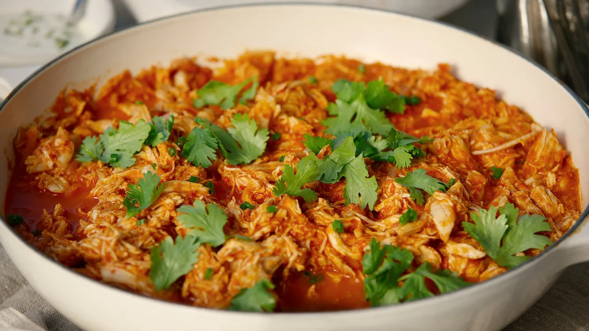 A bowl of chicken tinga dressed with cilantro.
