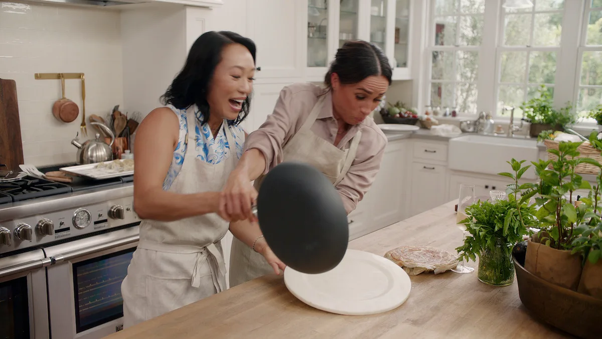 Vicky Tsai and Meghan flipping a pan of potstickers in the kitchen.