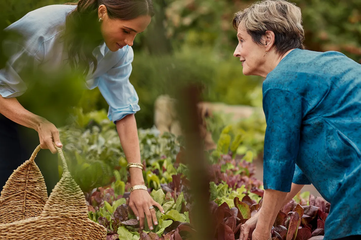 Meghan and Alice Waters picking lettuce together.