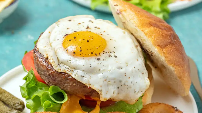 plated burger topped with egg